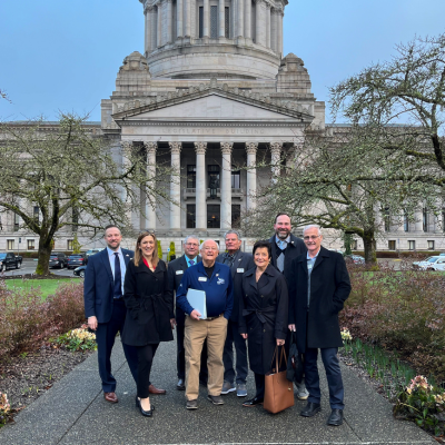 All seven City Councilmembers and City Manager stand in from of the Washington State Legislative Bui