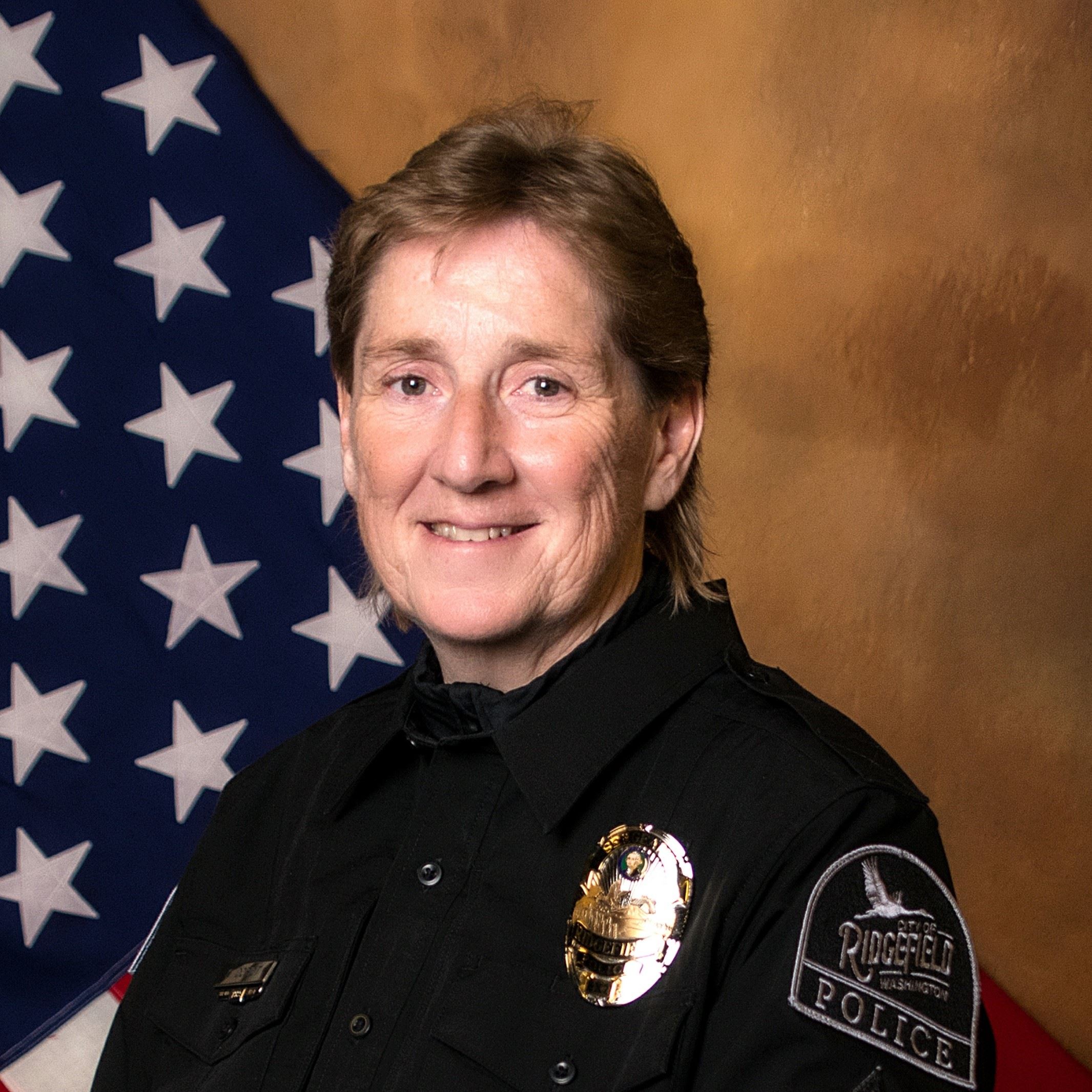 Head and shoulders portrait of Chief Doriot with an American flag in the background.